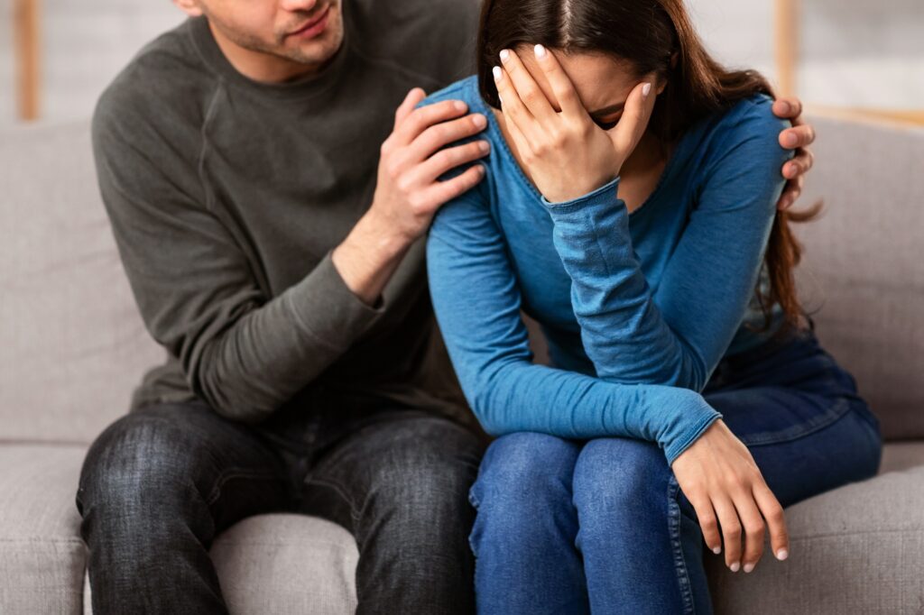 Man comforting and consoling his sad mourning friend